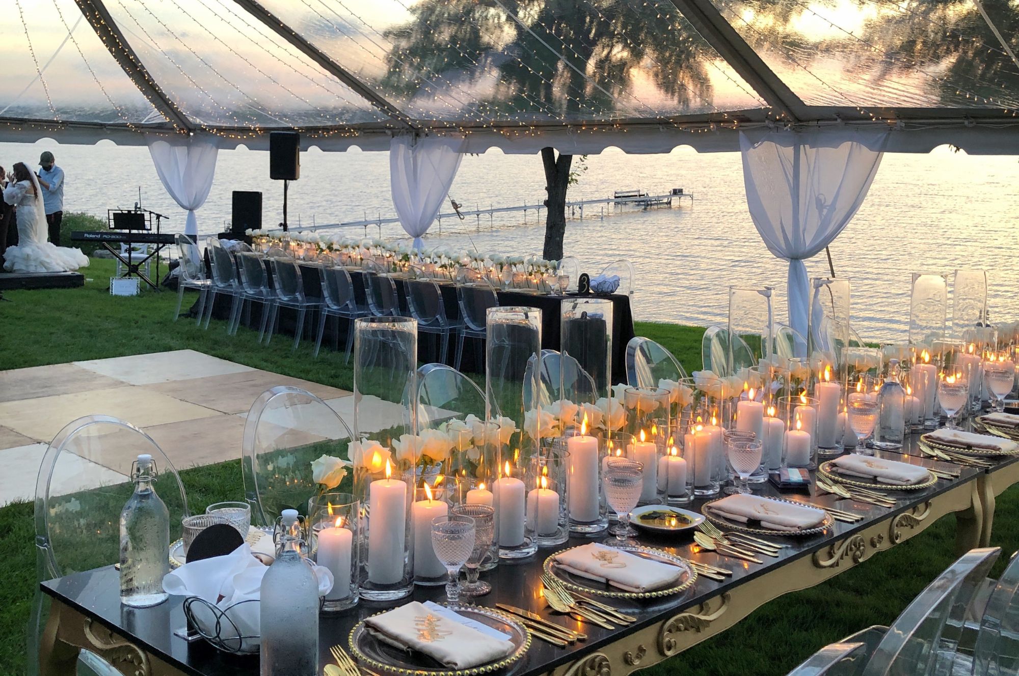 Lakeside candle lit tables under elegant clear wedding tent