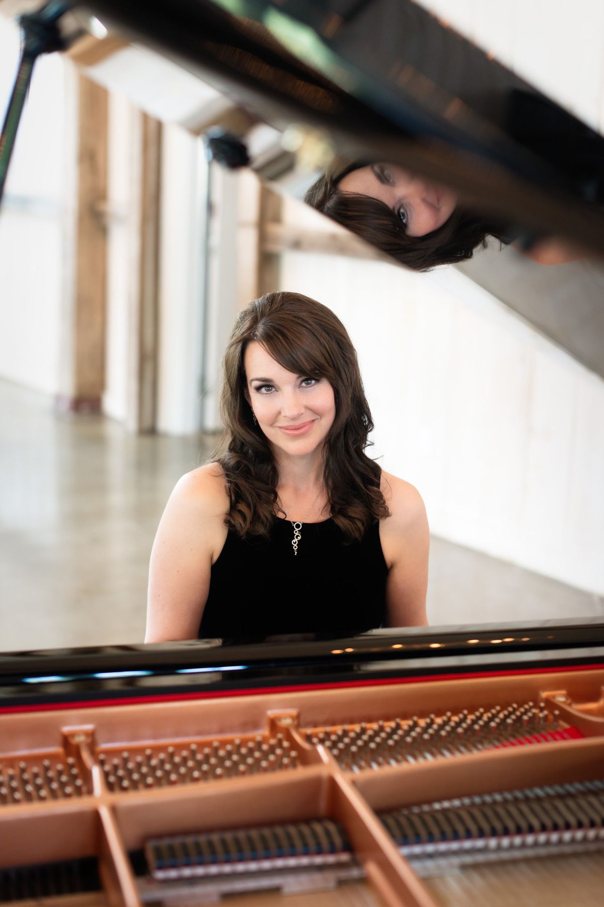 Kimberley Dunn performing as a singer and pianist at a grand piano during a wedding at Stonefields Estate.