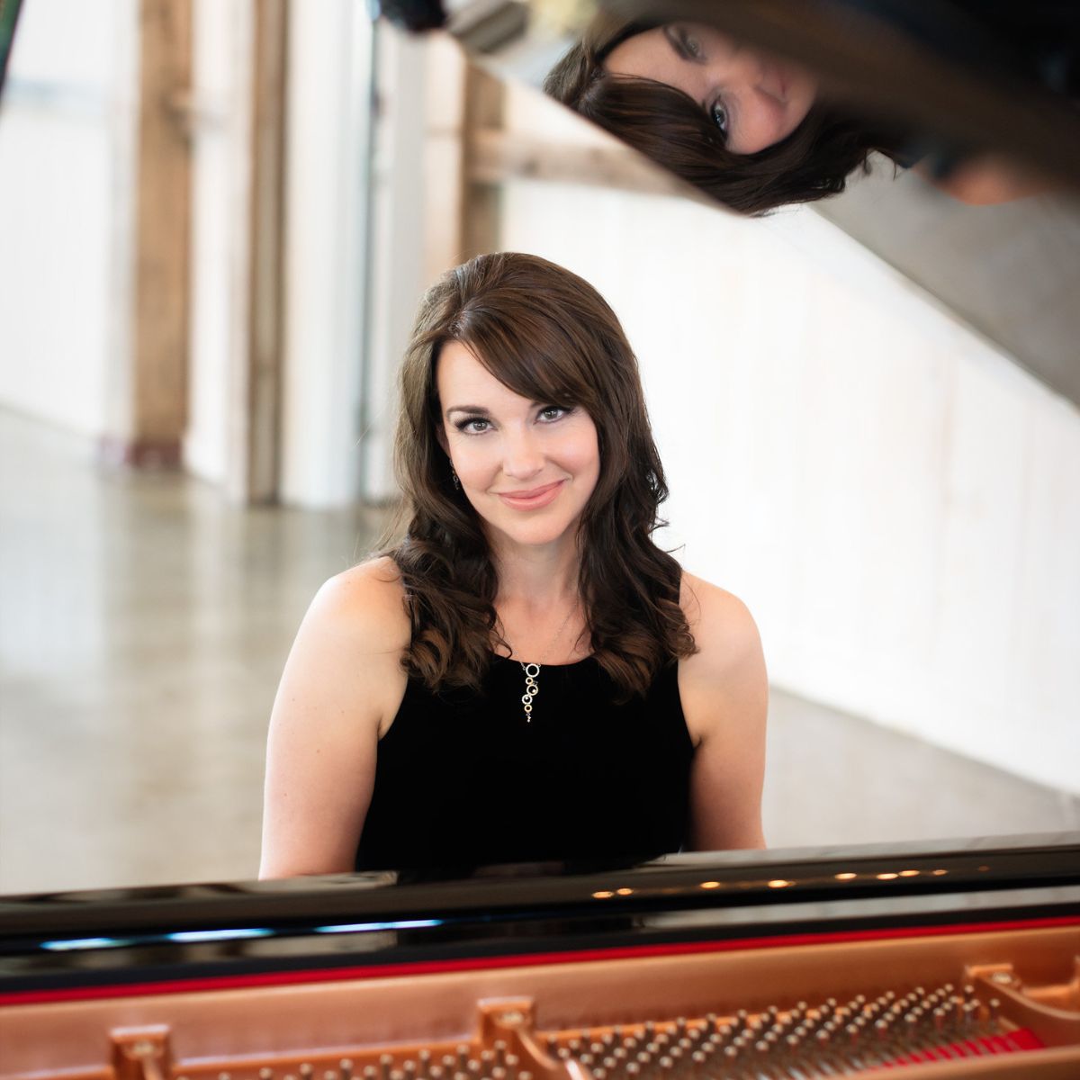 A cinematic live performance photo of Kimberley Dunn performing at an event, leading to the photo gallery.